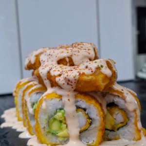 B-86). Sake ika especial (env. En salmón frito cubiertos de aros de calamar bañado de salsa acevichada y toques de chichimi)